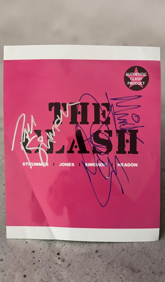Clash Signed Photograph: This lot is a photograph, autographed by Paul Simonon and Mick Jones of The Clash. If you wish to upgrade to a third party authentication with holographic QR code and item scoring, an additional charg