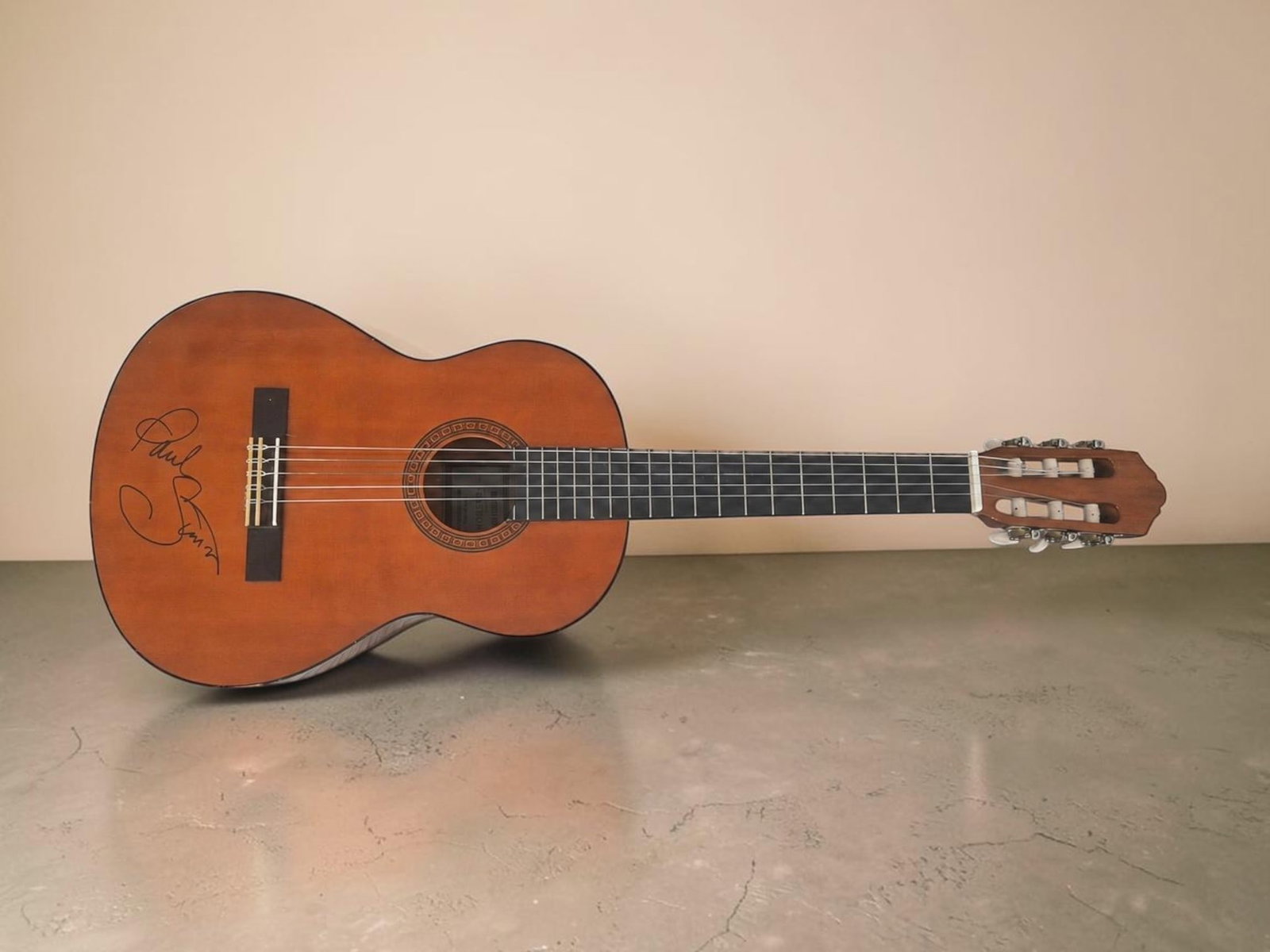 Paul Simon Signed Acoustic Guitar: This lot is an acoustic guitar, autographed by Paul Simon of Simon & Garfunkle fame. If you wish to upgrade to a third party authentication with holographic QR code and item scoring, an additional cha