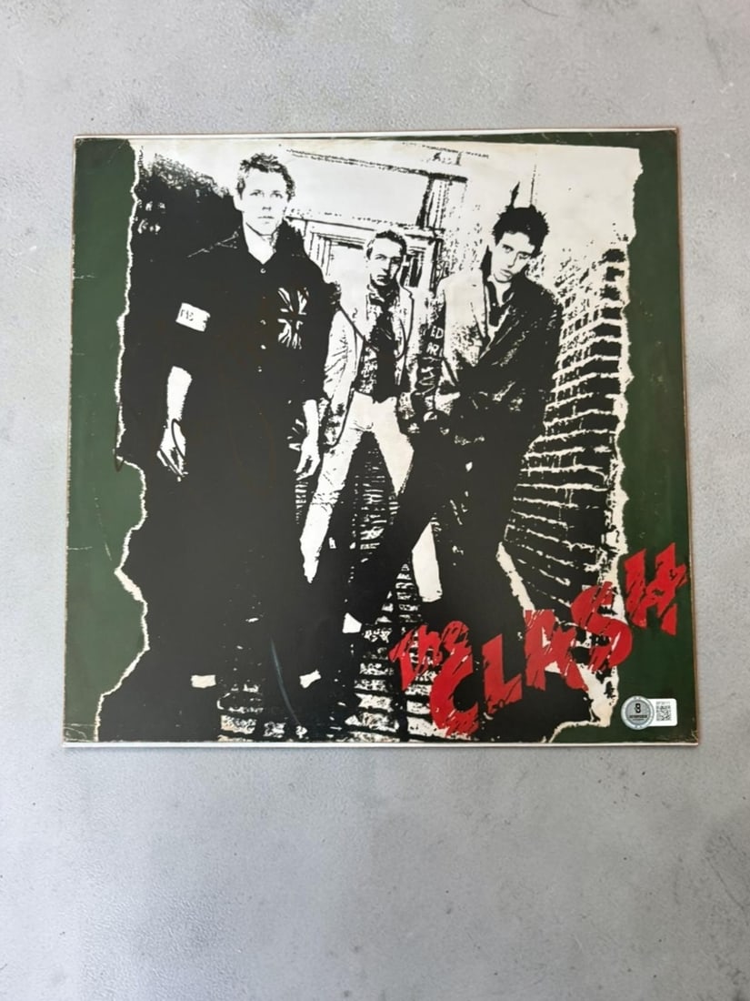 Paul Simonon The Clash Signed Photograph Beckett BAS Authenticated: This lot is a 12x12" photograph, autographed by Paul Simonon of The Clash. Item comes with Beckett BAS authentication. If you wish to upgrade to a third party authentication with holographic QR code a