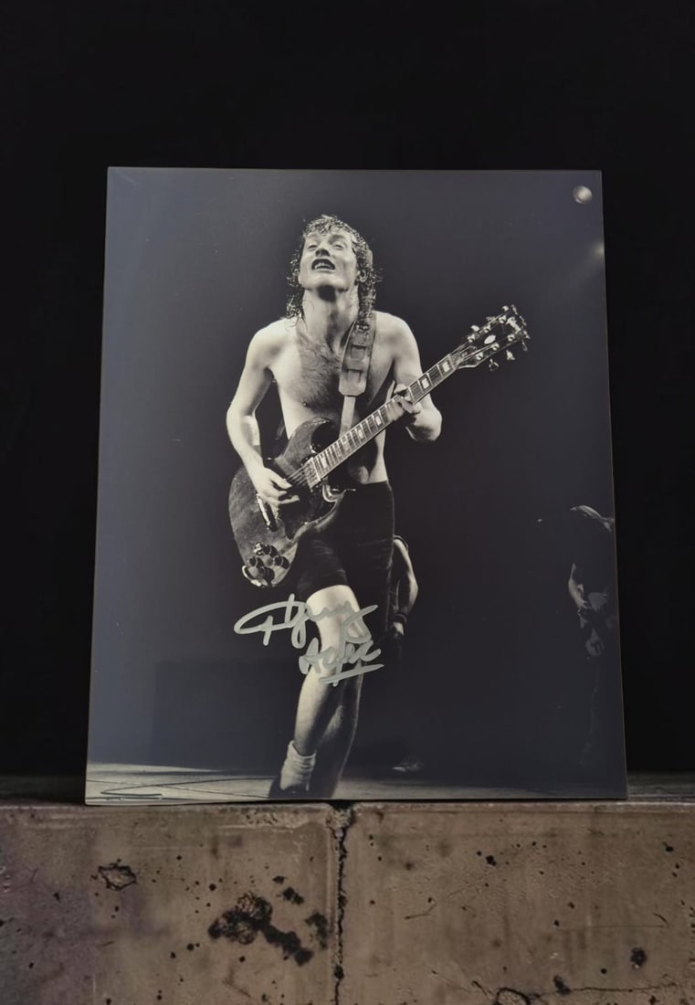 Angus Young AC/DC Signed Photograph: This lot is a photograph, autographed by Angus Young of AC/DC. If you wish to upgrade to a third party authentication with holographic QR code and item scoring, an additional charge of 30 UK pound
