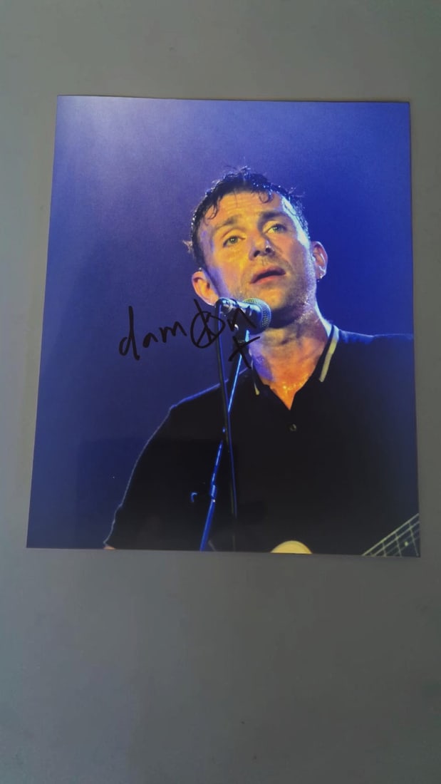 Damon Albarn Blur Signed Photograph: This lot is a photograph, autographed by Damon Albarn of Blur. If you wish to upgrade to a third party authentication with holographic QR code and item scoring, an additional charge of 30 UK Pound wou