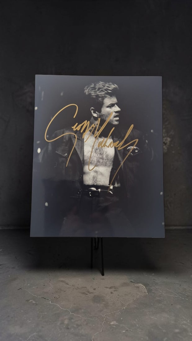 George Michael Signed Photograph: This lot is a photograph, autographed by George Michael. If you wish to upgrade to a third party authentication with holographic QR code and item scoring, an additional charge of 30 UK pound would be 