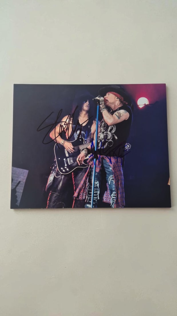 Guns N' Roses Signed Photograph: This lot is a photograph, autographed by Axl Rose and Slash of Guns N' Roses. If you wish to upgrade to a third party authentication with holographic QR code and item scoring, an additional charge of