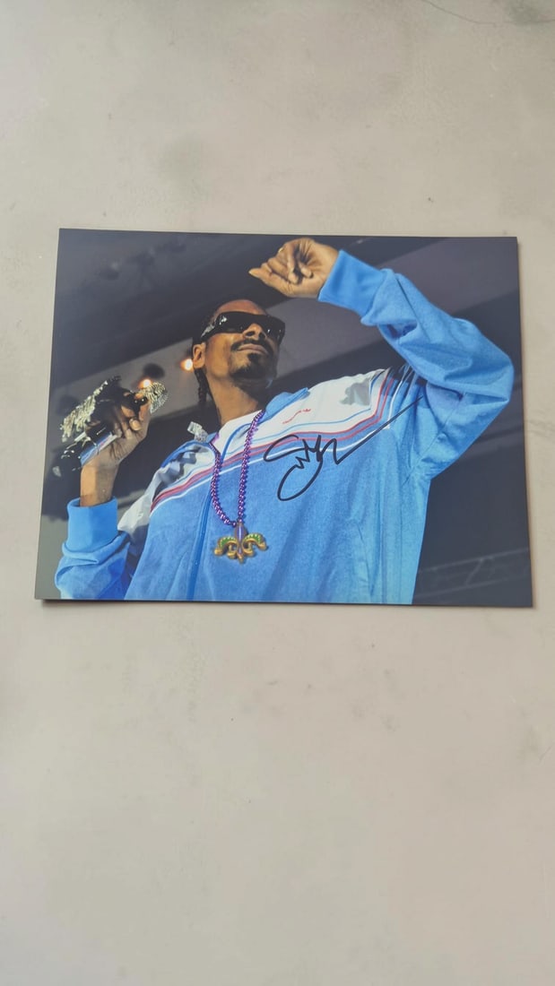Snoop Dogg Signed Photograph: This lot is a photograph, autographed by Snoop Dogg. If you wish to upgrade to a third party authentication with holographic QR code and item scoring, an additional charge of 30 UK Pound would be appl