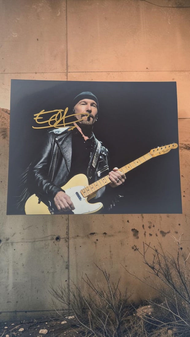 The Edge U2 Signed Photograph: This lot is a photograph, autographed by The Edge of U2. If you wish to upgrade to a third party authentication with holographic QR code and item scoring, an additional charge of 30 UK Pound would be 