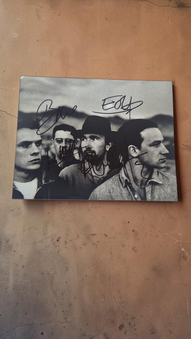 U2 Signed Photograph: This lot is a photograph, autographed by Bono, The Edge, Larry Mullen Jr and Adam Clayton of U2. If you wish to upgrade to a third party authentication with holographic QR code and item scoring, an