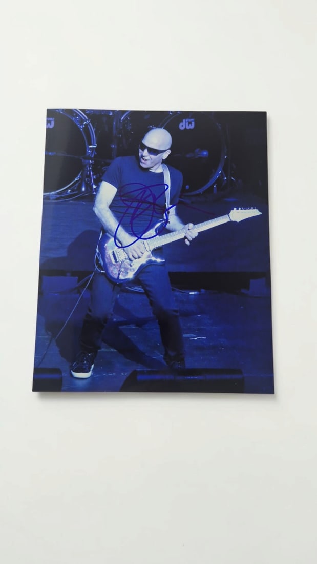 Joe Satriani Signed Photograph: This lot is a photograph, autographed by Joe Satriani. If you wish to upgrade to a third party authentication with holographic QR code and item scoring, an additional charge of 30 UK Poundwould be app