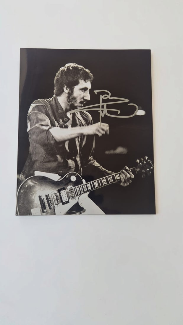 Pete Townshend The Who Signed Photograph: This lot is a photograph, autographed by Pete Townshend of The Who. If you wish to upgrade to a third party authentication with holographic QR code and item scoring, an additional charge of 30 UK