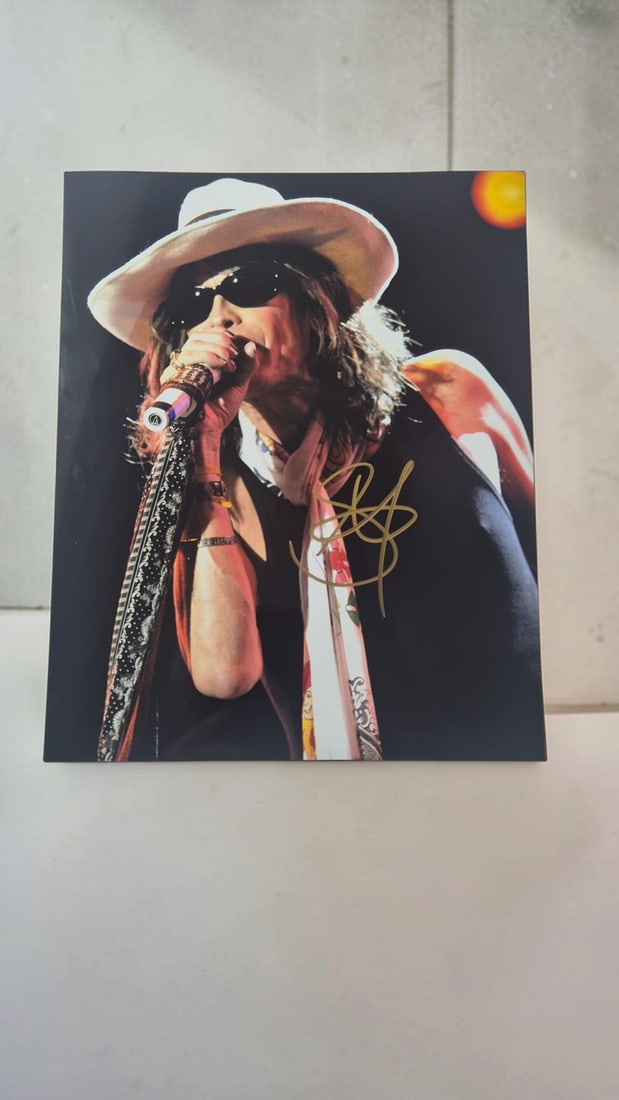 Steven Tyler Aerosmith Signed Photograph: This lot is a photograph, autographed by Steven Tyler of Aerosmith. If you wish to upgrade to a third party authentication with holographic QR code and item scoring, an additional charge of 30 UK Poun