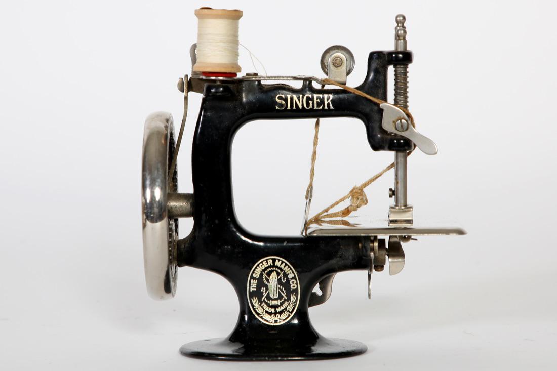 Child's Model No. 20 Singer Sewing Machine: Child's Singer Sewing Machine complete with clamp in working condition. Model No. 20. Comes with original instruction manual and original box in rough condition. Condition: Good. Size: 6 1/2" W x 6 1/