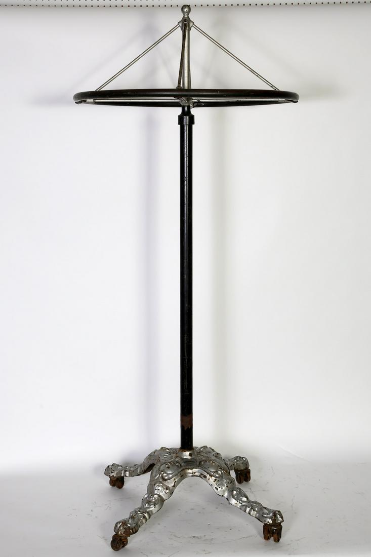 Great Western Fixture Co. Revolving Clothing Rack: Tall Ornate Clothing Rack w/Revolving top mfg. by Great Western Fixture Co. Chicago,IL. It has an ornate cast iron base, iron center column & brass revolving top ring. Condition:Good. Size: 30" D x 70