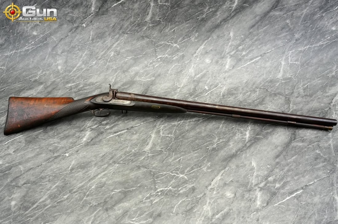 Vintage "Fine Stuc Twist" Double Barrel 10 Ga. Shotgun, 32.5" Barrel, Fair Condition This antique: Vintage "Fine Stuc Twist" Double Barrel 10 Ga. Shotgun, 32.5" Barrel, Fair ConditionThis antique black powder firearm features a scroll-engraved lockplate, laminated Damascus steel barrels, dual exter