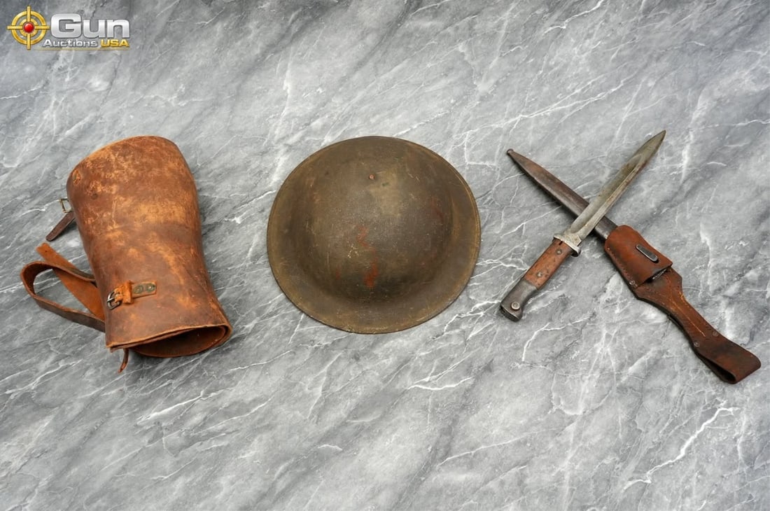 Aug. Kupper Solingen Bayonet, Helmet & Leg Guard.: Aug. Kupper Solingen bayonet, helmet & leg guard. Good Condition.This militaria grouping includes a German Gewehr 98/Karabiner 98k bayonet marked "AUG. KUPPER SOLINGEN" with wooden grip scales, a stee