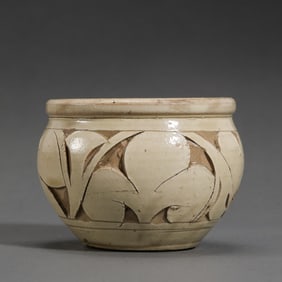 A white-glazed jar with carved floral patterns from the Cizhou kiln of the Northern Song Dynasty,
