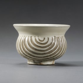 A white-glazed, carved spittoon from the Cizhou kiln of the Northern Song Dynasty in China.