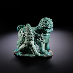 A turquoise statue of a Central Asian man leading a lion from the Liao Dynasty in China.