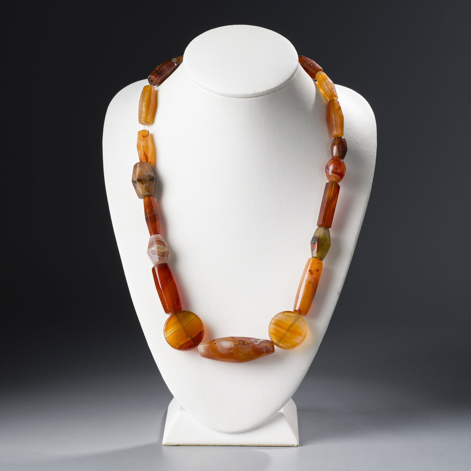 ANTIQUE CARNELIAN JEWELRY TRADE BEADS [24PCS, 153G]: A collection of 24 antique carnelian trade beads, weighing a total of 153 grams. These beads feature rich orange-red tones and smooth, time-worn surfaces, reflecting their use in historic jewelry and