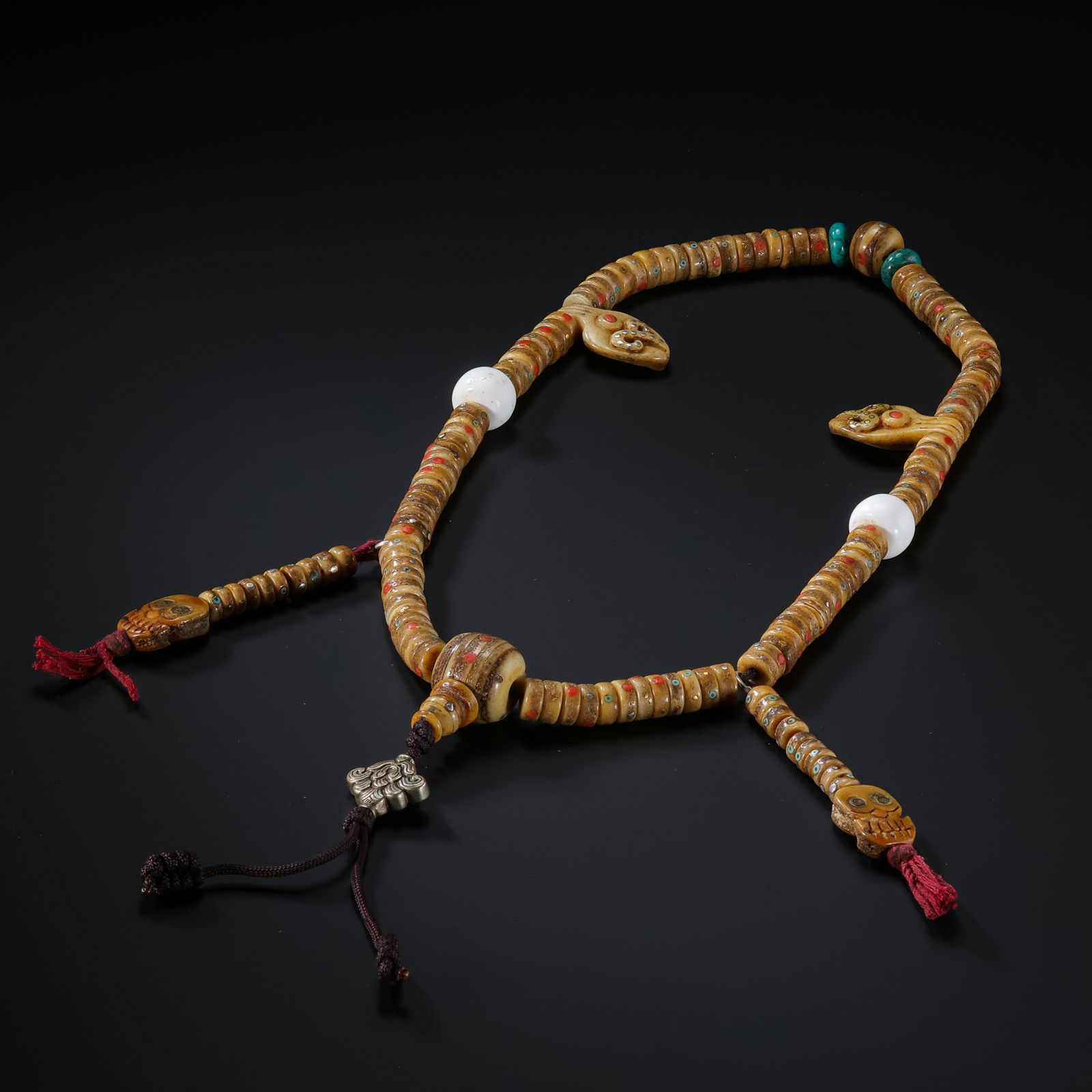 AN IMPORTANT AND HIGHLY DECORATED INLAID 'KAPALA' (HUMAN SKULL) ROSARY,MALATIBET (LHASA REGION),: Description This extraordinary rosary, or Mala, is composed of 108 disc-shaped beads meticulously fashioned from human cranium bone (Kapala). In Tibetan Buddhism, Kapala beads symbolize the impermanen