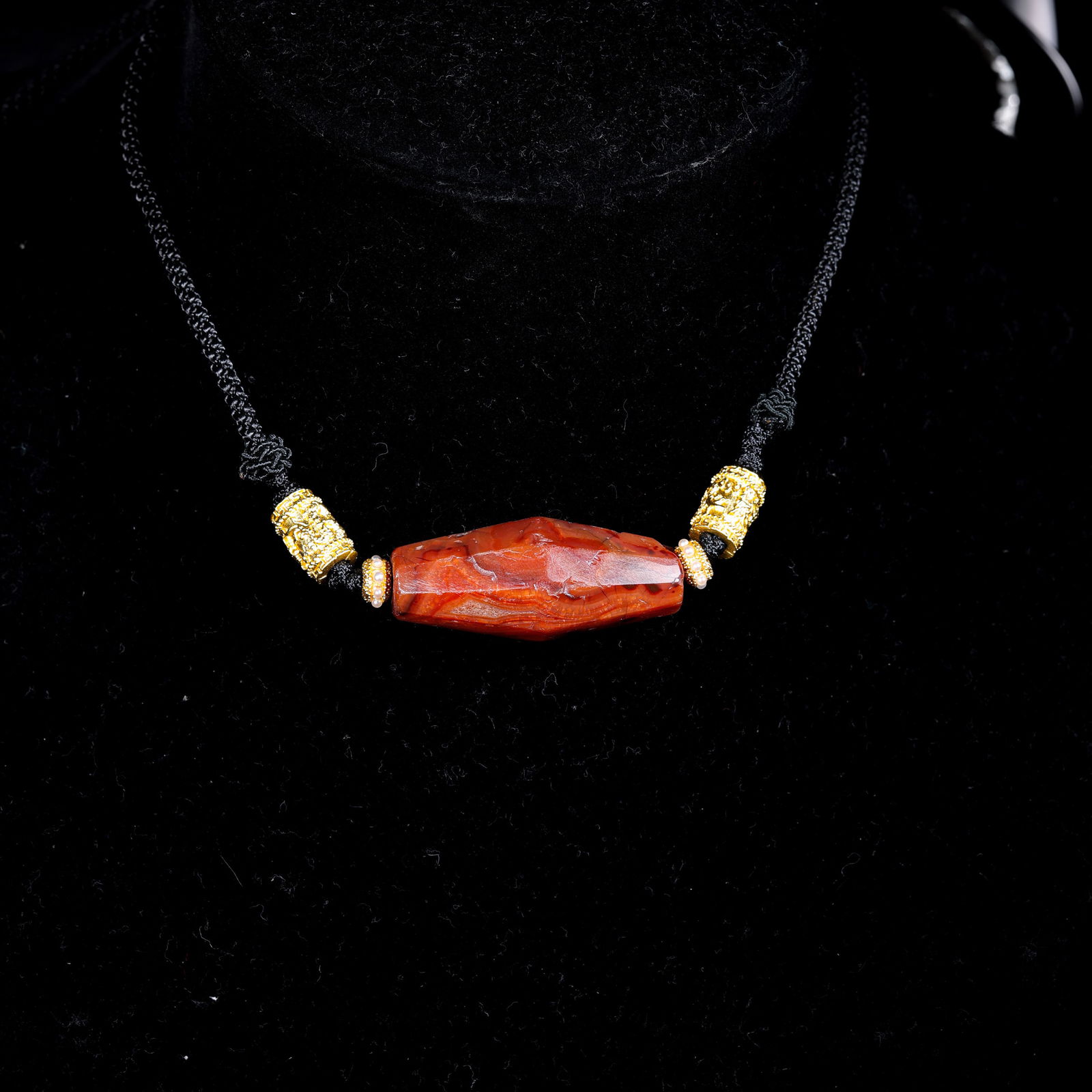 A RARE AND IMPORTANT FACETED RED CARNELIAN 'SPINDLE' BEADHIMALAYAN REGION / TIBET, ANCIENT PERIOD: DescriptionThis exceptional and highly geometric bead is fashioned from a premium, semi-translucent red carnelian (hong-ma-nao). The stone exhibits a deep, saturated ferruginous red hue, which glows w