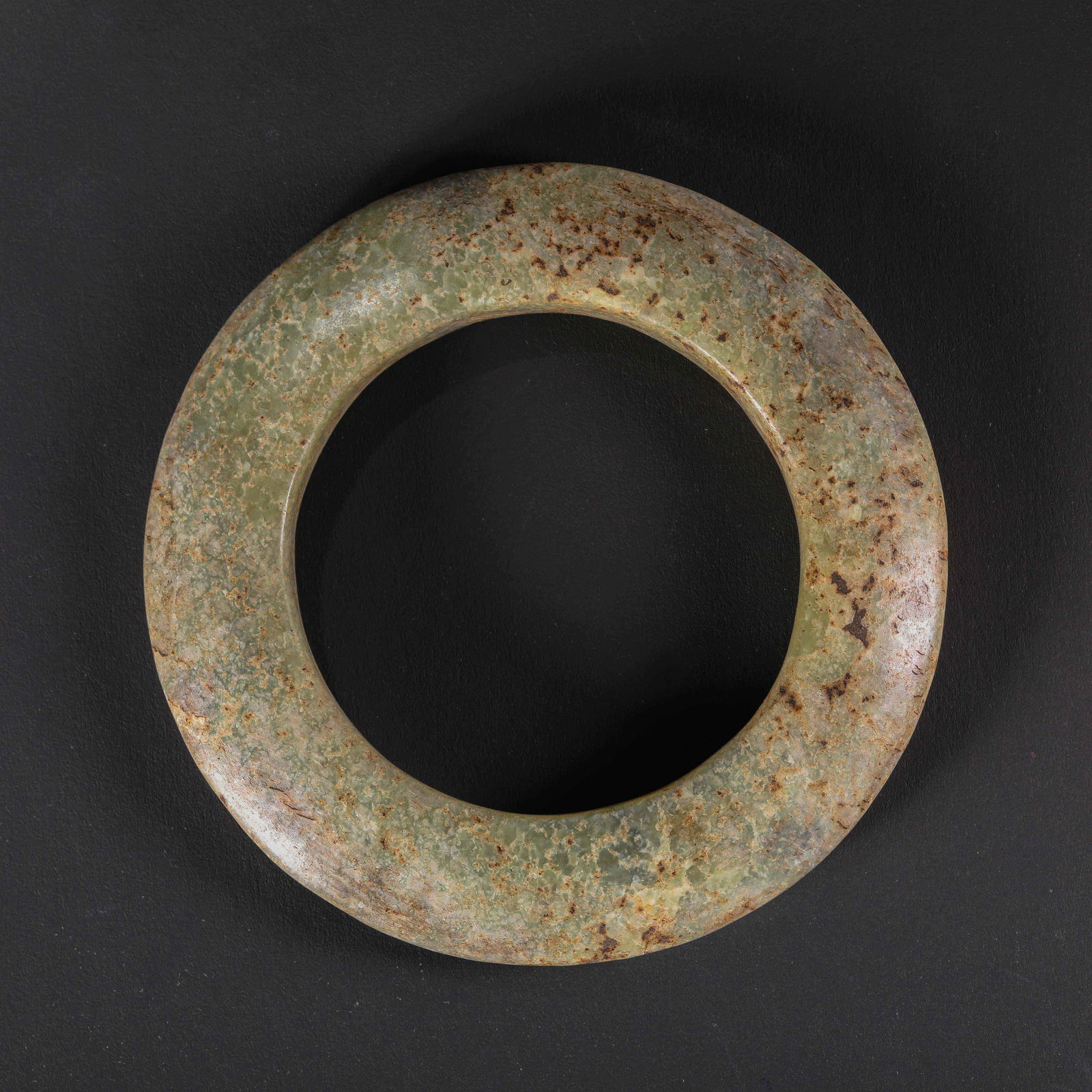 A RARE AND MAGNIFICENT LARGE GREENISH-YELLOW JADE RITUAL DISC,HUANHONGSHAN CULTURE, NEOLITHIC PERIOD: Description This monumental circular disc is masterfully fashioned from a solid piece of greenish-yellow jade (nephrite). With a commanding diameter of 10.8 cm, this is a significant ritual object rat