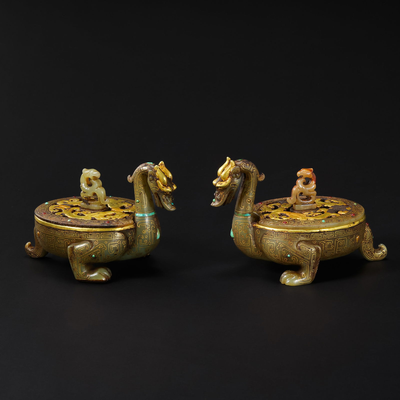 A SPECTACULAR PAIR OF GOLD-INLAID AND TURQUOISE-SET JADE RITUAL VESSELS,HEWARRING STATES PERIOD: Description This exceptional pair of ritual vessels is masterfully sculpted from high-quality Hetian jade, each fashioned in the form of a majestic long-necked dragon in a contemplative, bowing postur