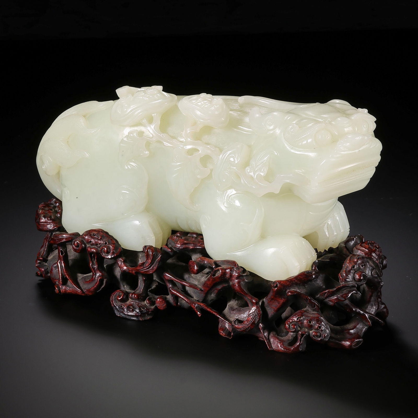 A MONUMENTAL AND RARE WHITE JADE FIGURE OF A RECLINING LION WITHLINGZHIQING DYNASTY, QIANLONG PERIOD: Description This exceptionally large and powerfully carved figure is fashioned from a single, substantial block of premium Hetian white jade. The stone exhibits a remarkable "mutton-fat" luster, posse