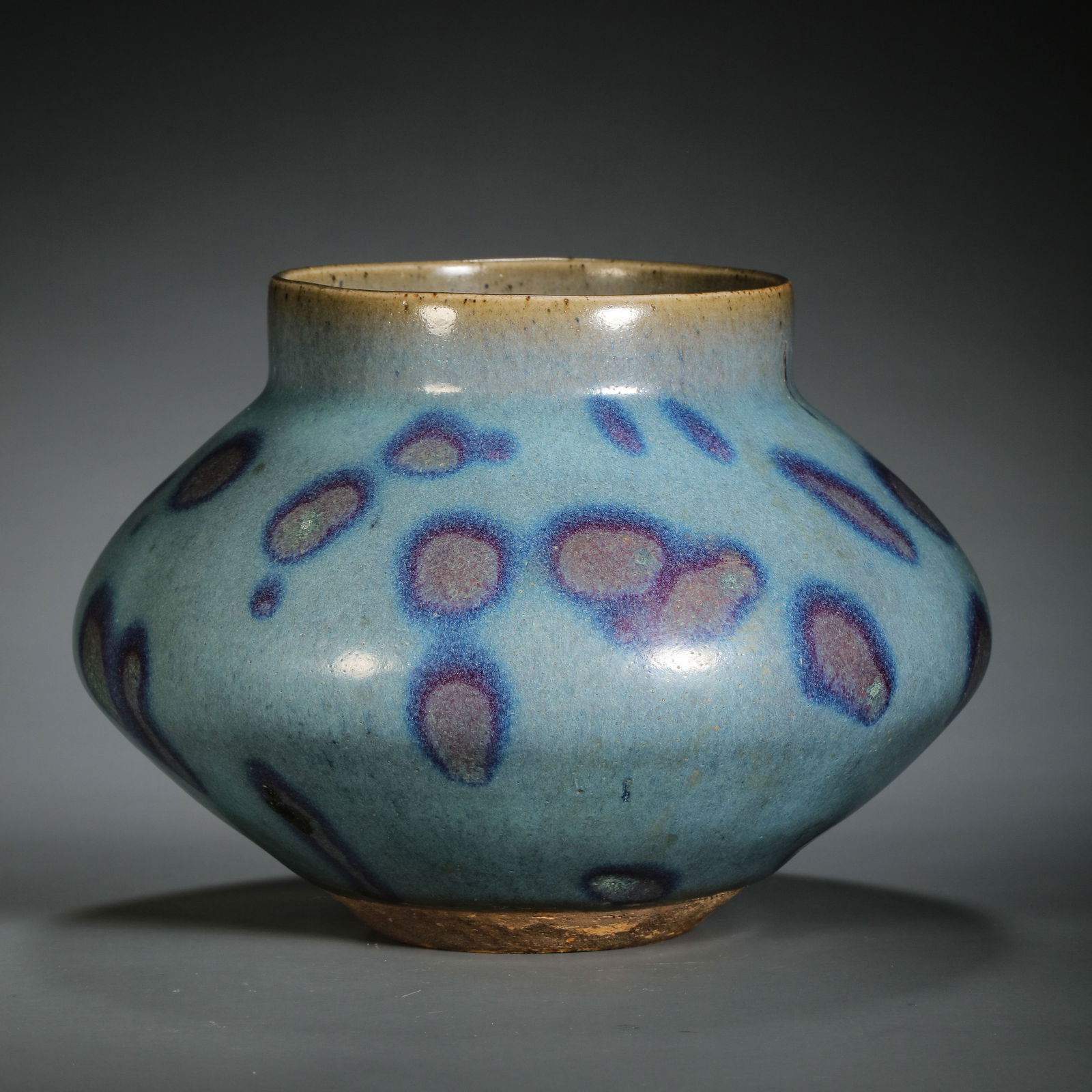 A RARE AND MAGNIFICENT 'JUN' SPLASHED CELADON-GLAZED JARSONG TO JIN DYNASTY (12TH - 13TH CENTURY): Description The jar is powerfully potted with a wide, robust globular body rising to a short, slightly waisted neck and a broad, flaring rim. It is enveloped in a thick, opulent glaze of a pale sky-bl