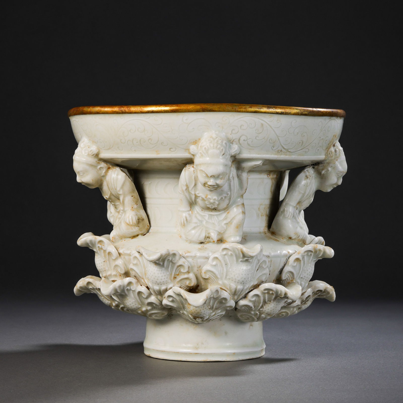 A RARE AND MAGNIFICENT WHITE-GLAZED 'DING' WARE STEM PLATE WITH APPLIED 'LISHI' FIGURESLIAO DYNASTY: DescriptionThe vessel is masterfully potted with a broad, shallow circular dish supported on a robust, spreading stem and a stepped pedestal base. The interior of the dish is elegantly decorated with