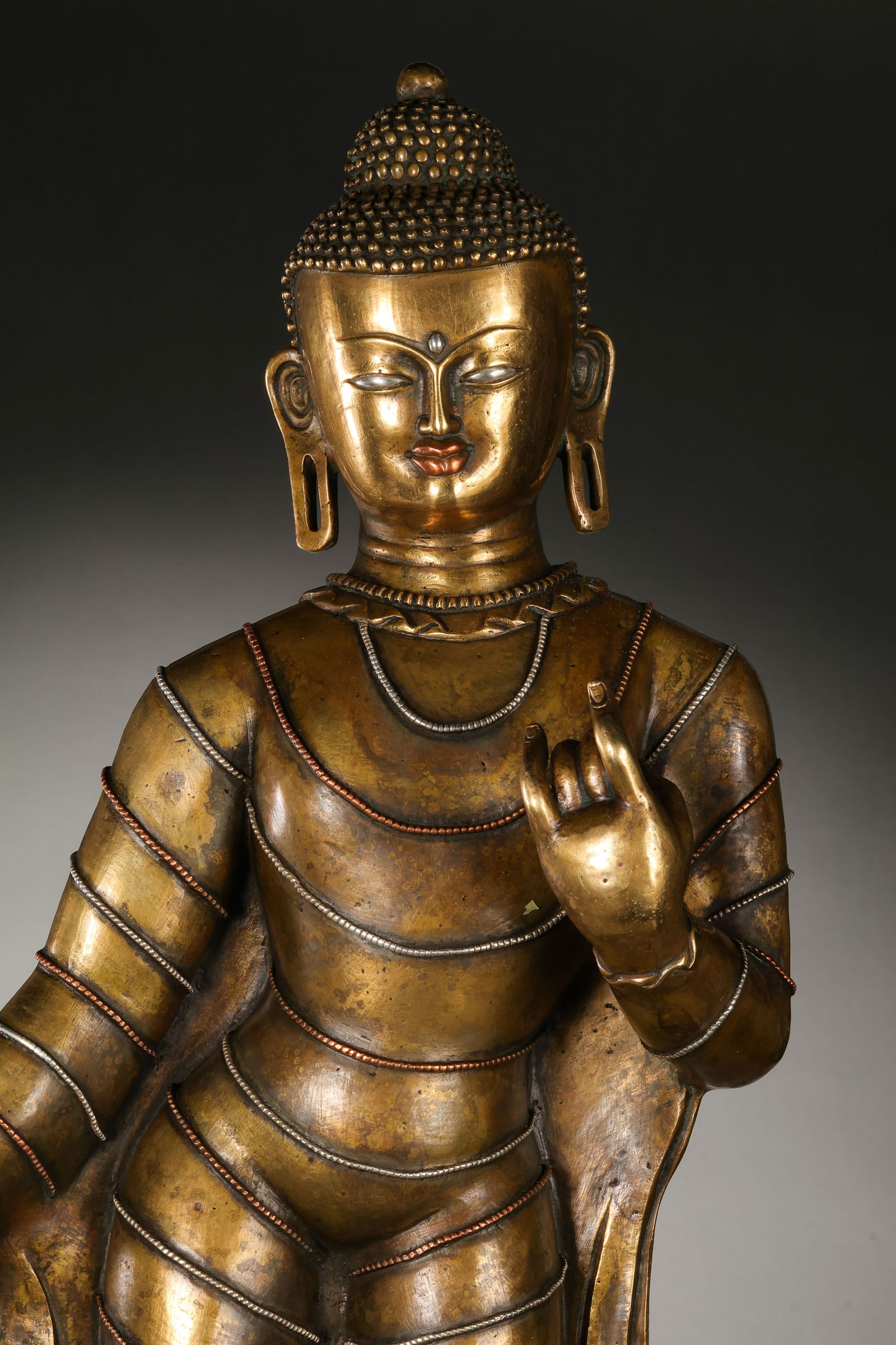 RARE AND MAGNIFICENT COPPER-ALLOY FIGURE OF STANDING BUDDHA SHAKYAMUNIHIMALAYAN REGION (TIBET OR: Description This monumental statue depicts the Historical Buddha, Shakyamuni, standing in a graceful tribhanga (triple-bend) pose. The figure is masterfully cast from a superior copper alloy (hun-he-t