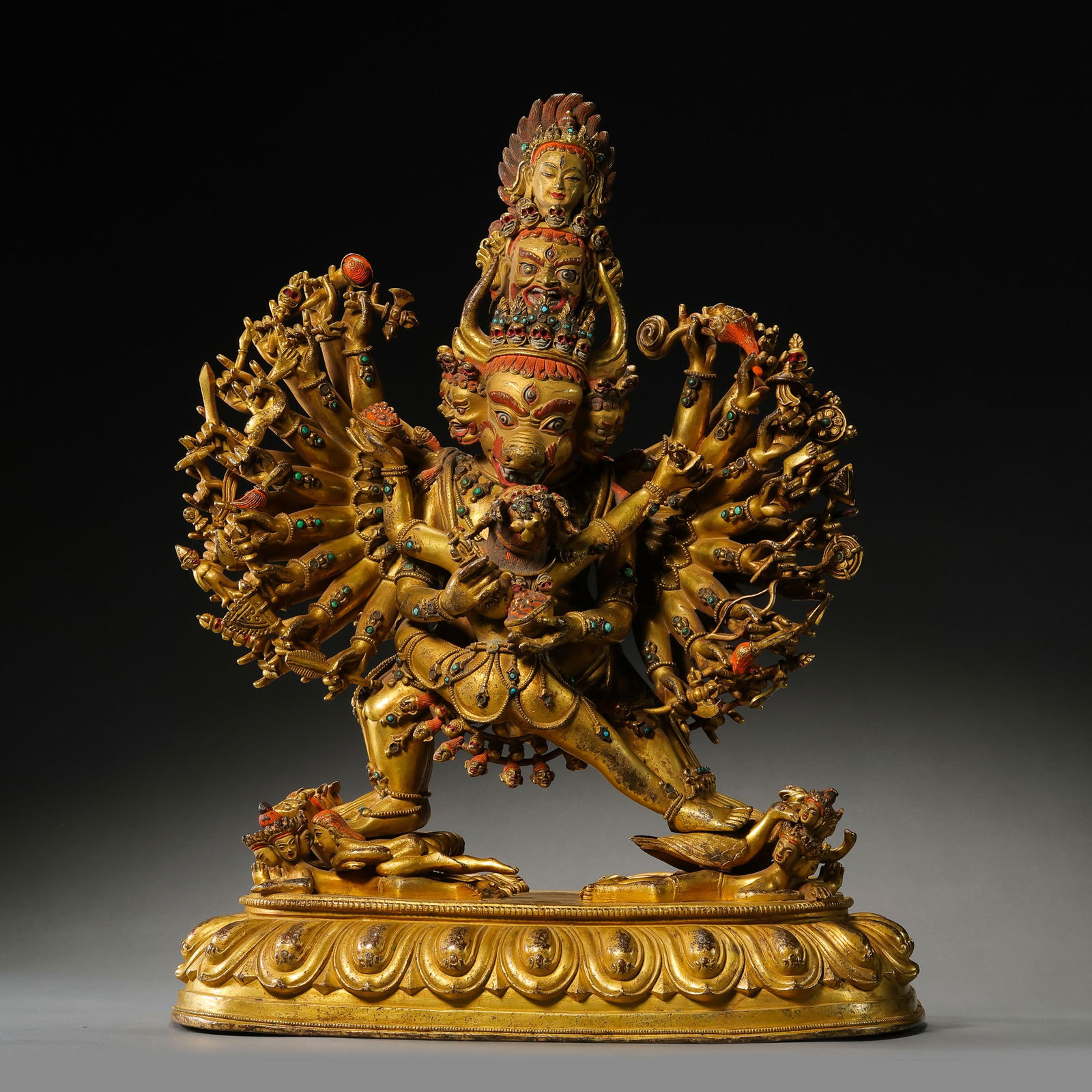 A MAGNIFICENT AND MONUMENTAL GILT-BRONZE FIGURE OF YAMANTAKA VAJRABHAIRAVA AND CONSORTMING DYNASTY: Description This colossal and powerfully cast bronze figure depicts the multi-armed, multi-headed deity Yamantaka Vajrabhairava in union (yab-yum) with his consort, Vajravetali. The deity stands in a