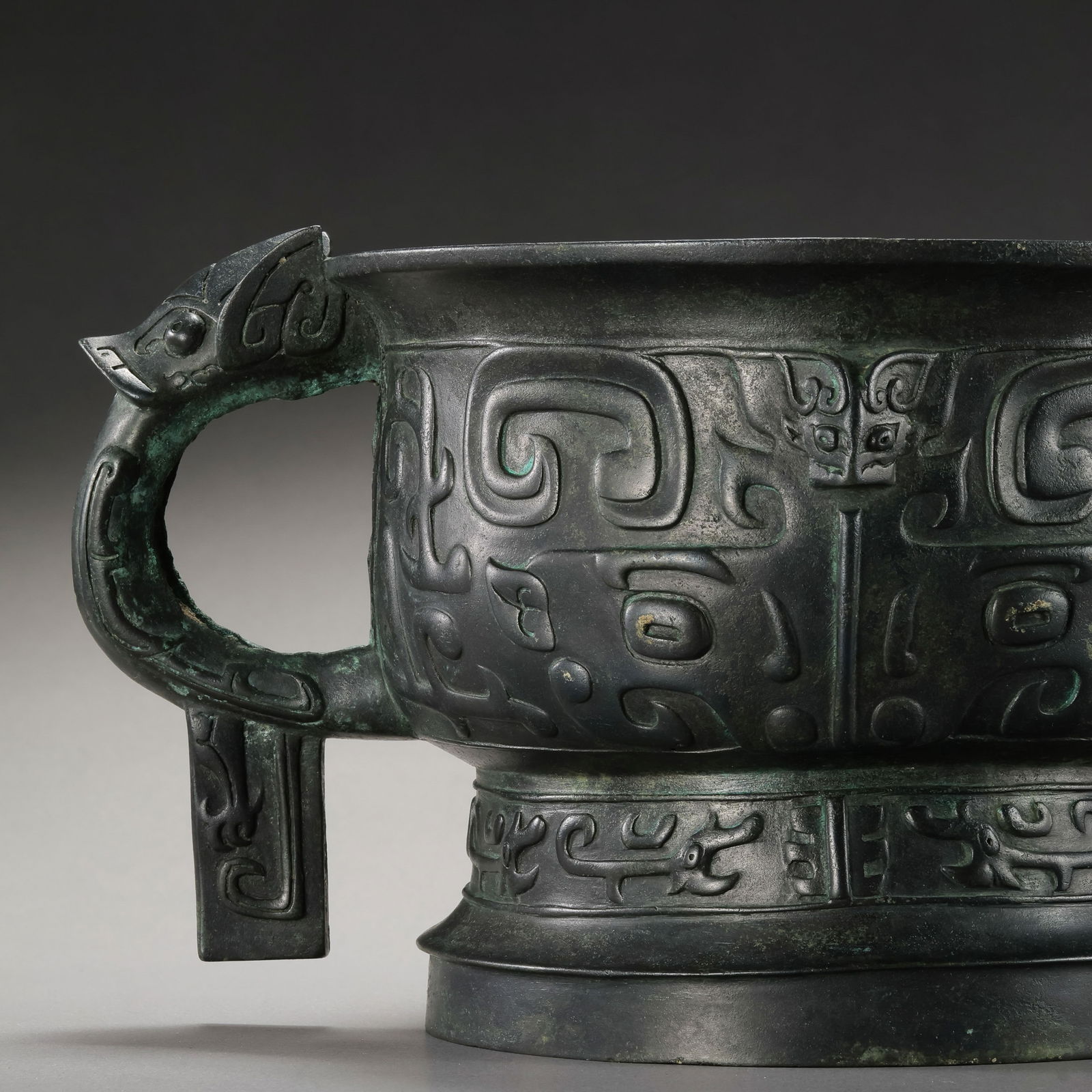 A RARE AND IMPORTANT BRONZE RITUAL FOOD VESSEL,GUILATE SHANG TO EARLY WESTERN ZHOU DYNASTY (C. 11TH: DescriptionThis robustly cast bronze vessel, known as a Gui, is a classic example of the ritual regalia from the height of China’s Bronze Age. The vessel features a deep, compressed globular body su