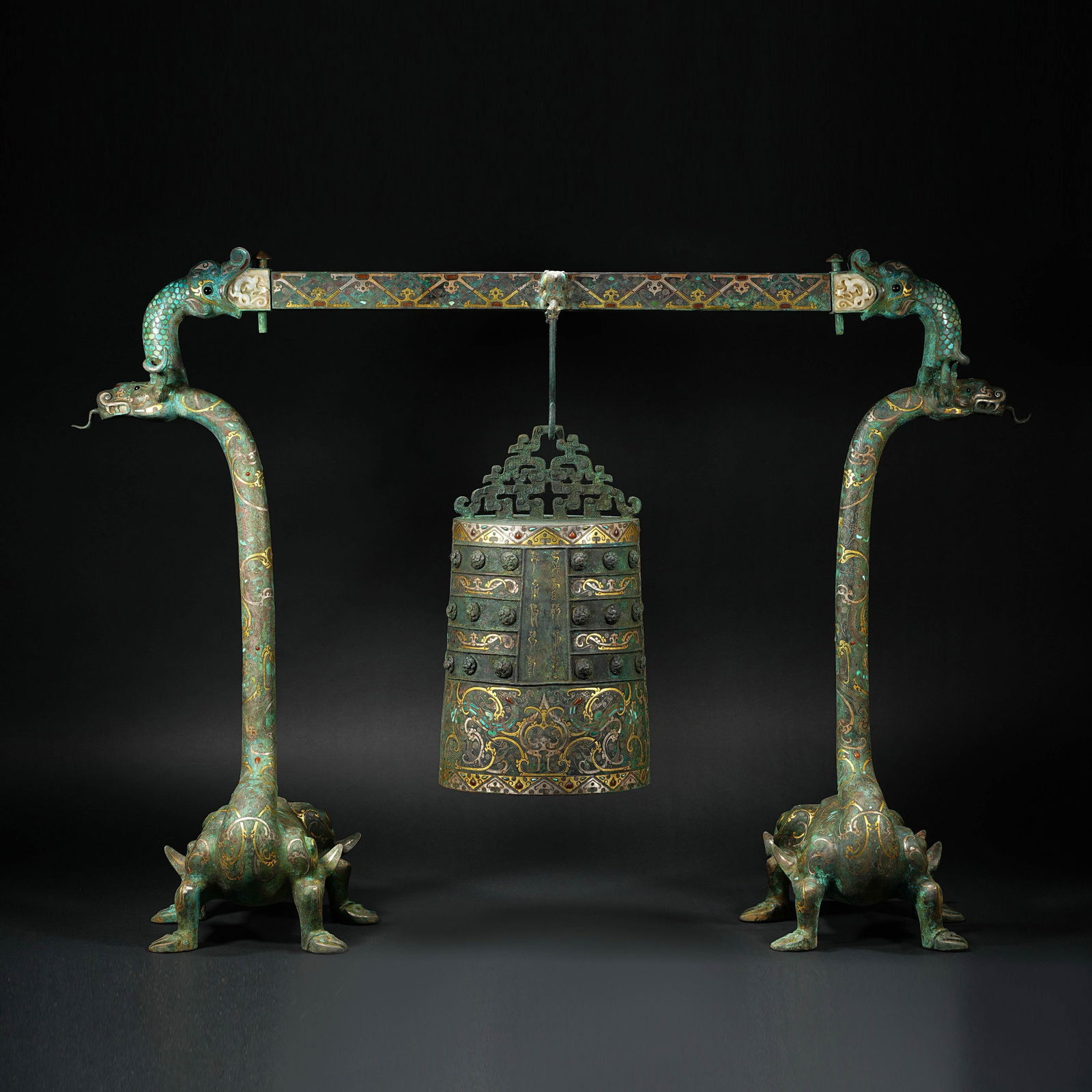 A MAGNIFICENT AND HIGHLY IMPORTANT GOLD, SILVER, TURQUOISE AND JADE-INLAID BRONZE BELL (ZHONG) AND: Description This extraordinary ensemble is a masterwork of ancient Chinese metallurgy and lapidary art. The set comprises a large bronze bell (Zhong) suspended from an elaborate, double-headed mythica