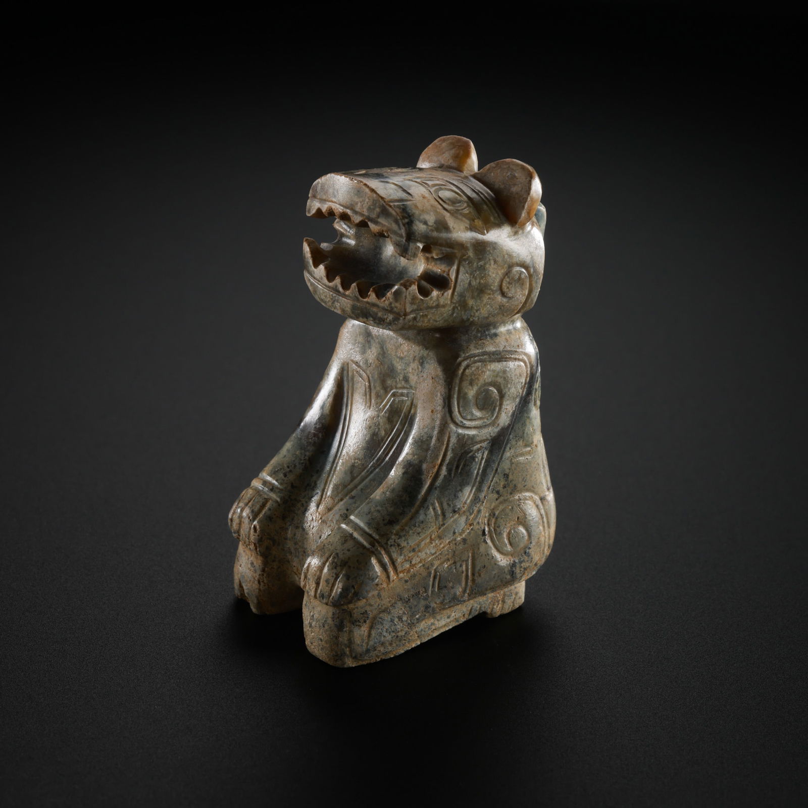 A MAGNIFICENT AND SUBSTANTIAL WHITE JADE FIGURE OF A SEATED MYTHICAL BEASTHAN DYNASTY (206 BC –: The monumentally proportioned jade figure is exceptionally carved from a solid, heavy block of pale celadon-white Hetian jade. The beast is depicted in a powerful kneeling position (jizuo), with its l