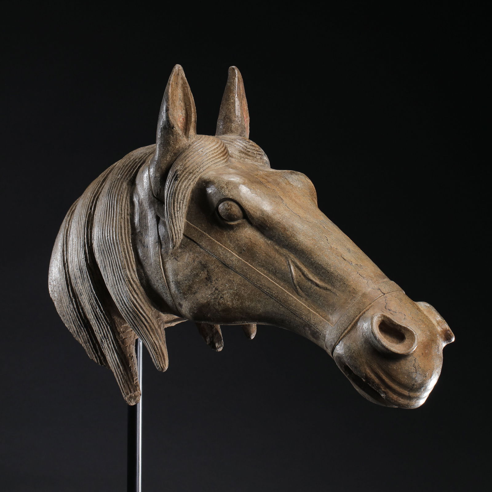 A RARE AND POWERFULLY CARVED BLUESTONE HEAD OF A HORSETANG DYNASTY (618-907) OR LATER: Description The limestone head is masterfully carved with the robust and spirited proportions characteristic of the Tang imperial style. The horse is depicted with an alert and vigorous expression, fe