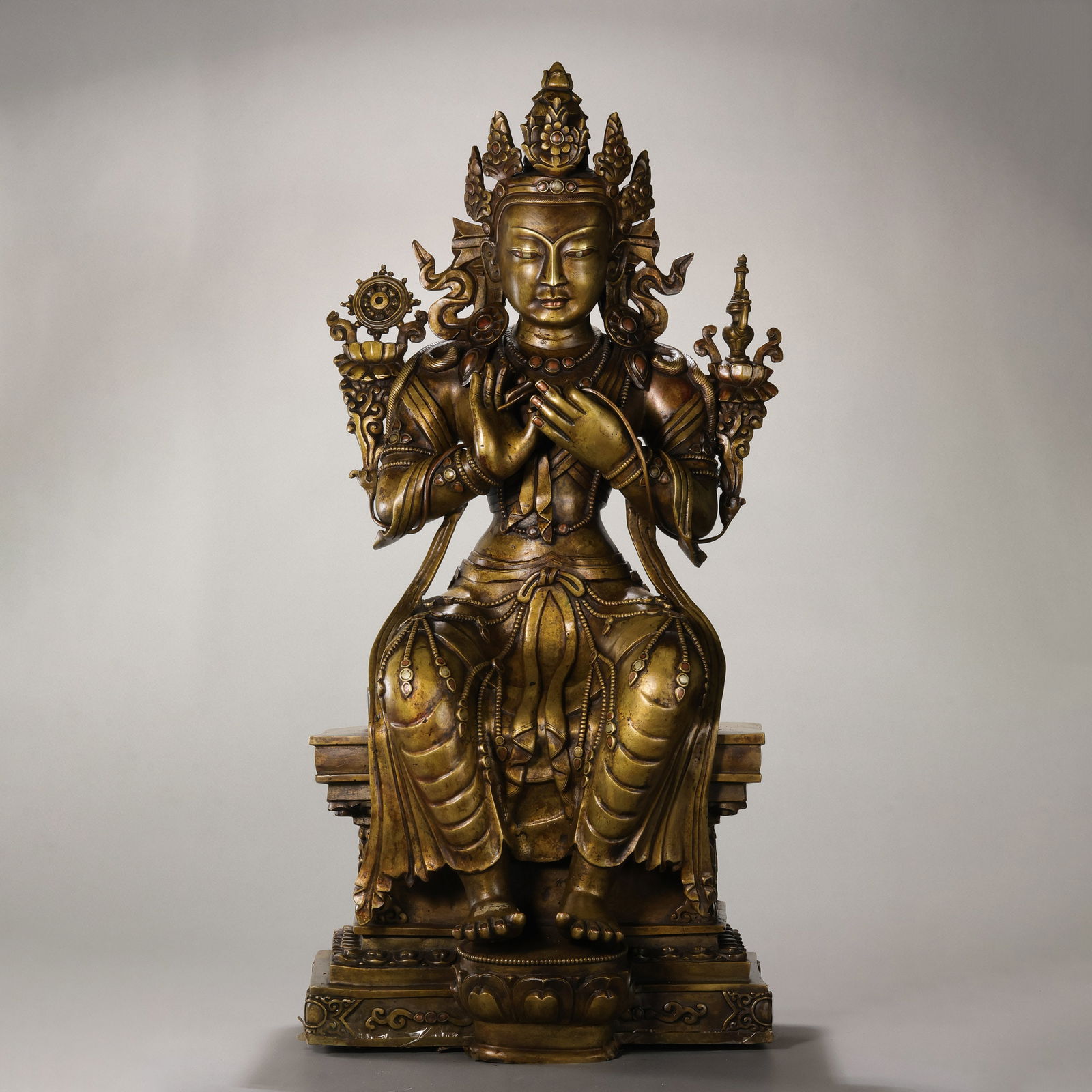 A RARE AND MONUMENTAL MULTI-ALLOY FIGURE OF MAITREYATIBET, 14TH - 15TH CENTURY: DescriptionThis colossal and masterfully cast statue depicts Maitreya, the Future Buddha, seated in the regal bhadrasana (European pose) atop a high rectangular throne. The statue is a technical tour-
