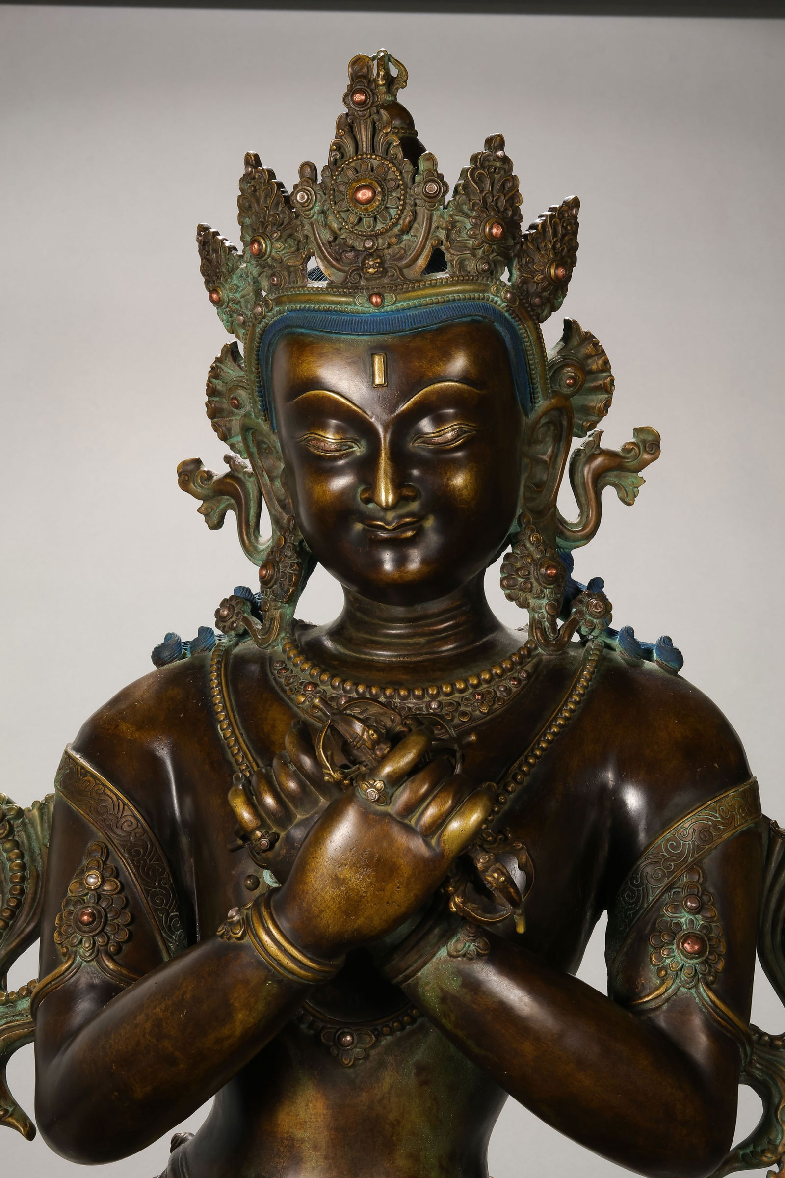 A RARE AND MONUMENTAL MULTI-ALLOY FIGURE OF VAJRADHARATIBET, 14TH - 15TH CENTURY: Description This colossal and exceptionally cast figure depicts Vajradhara, the primordial Buddha and the source of all tantric lineages. The deity is shown seated in the meditative posture of vajrapa