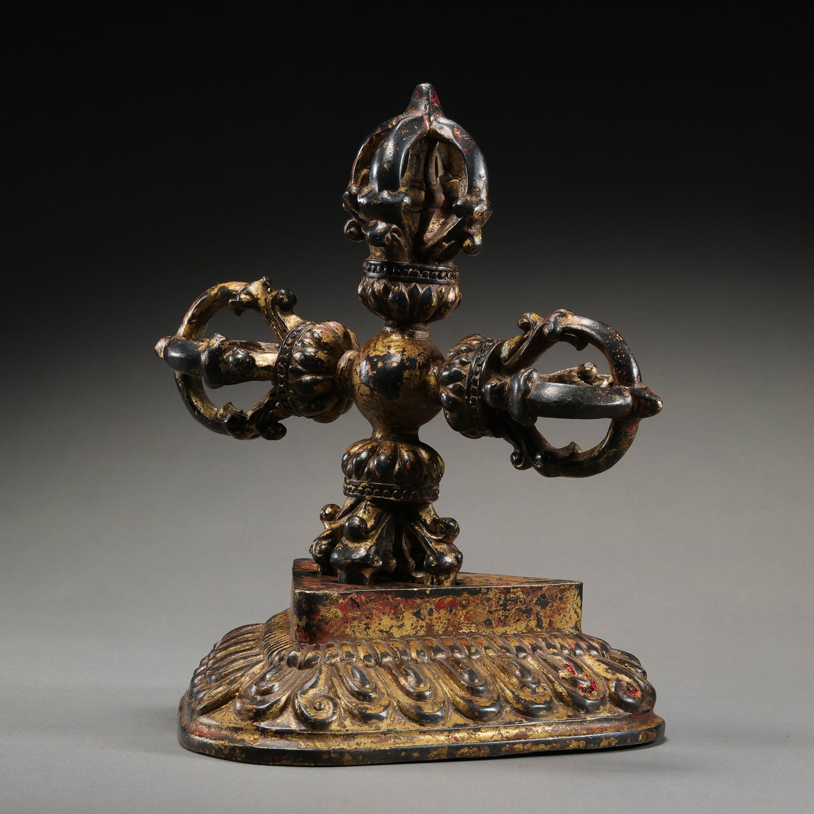 A RARE AND MAGNIFICENT COLD-GILDED BRONZE 'VISVAVAJRA' AND ORIGINAL LOTUS BASETIBET, 17TH - 18TH: Description This exceptional ritual implement consists of a monumental Visvavajra (Double Thunderbolt) and its rare, original triangular lotus pedestal. The object is cast in high-quality copper alloy