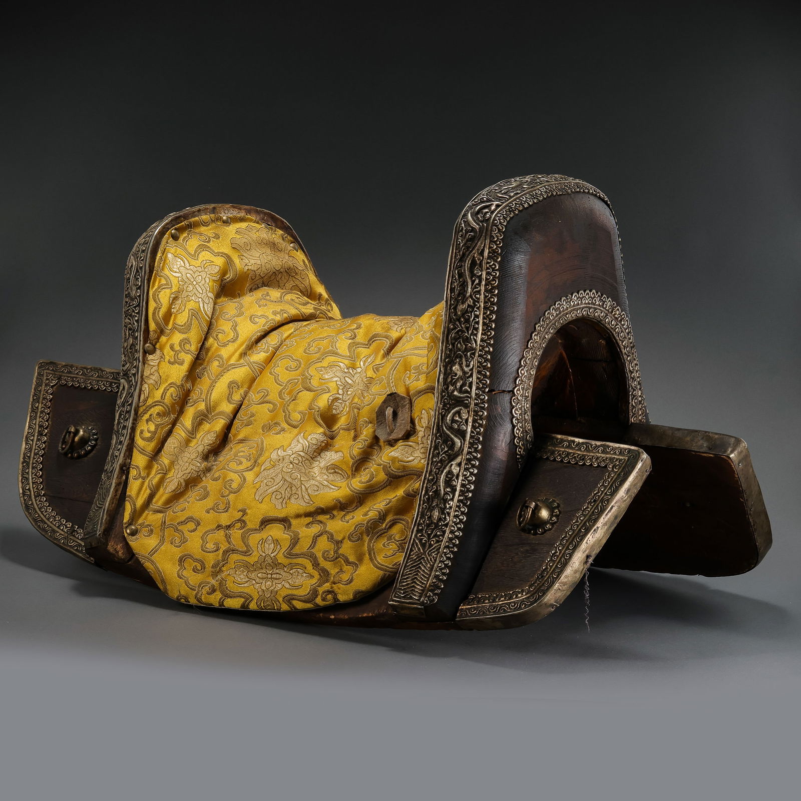 RARE AND MAGNIFICENT SILVER-MOUNTED WOOD SADDLE WITH DRAGON MOTIFSQING DYNASTY (1644-1911): Description The saddle is robustly constructed with a wooden frame, featuring a high, elegantly curved pommel and cantle, characteristic of the Manchu military and ceremonial style. The wooden core is