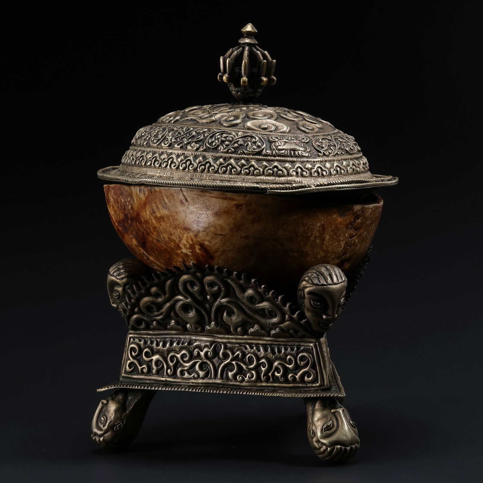 A RARE AND MAGNIFICENT SILVER-MOUNTED KAPALA (SKULL CUP), COVER AND STANDTIBET, LATE 18TH – 19TH: Description This exceptional ritual vessel is composed of a human cranium (Kapala), meticulously prepared and lined with silver. It is presented as a complete set with a sumptuously decorated cover an