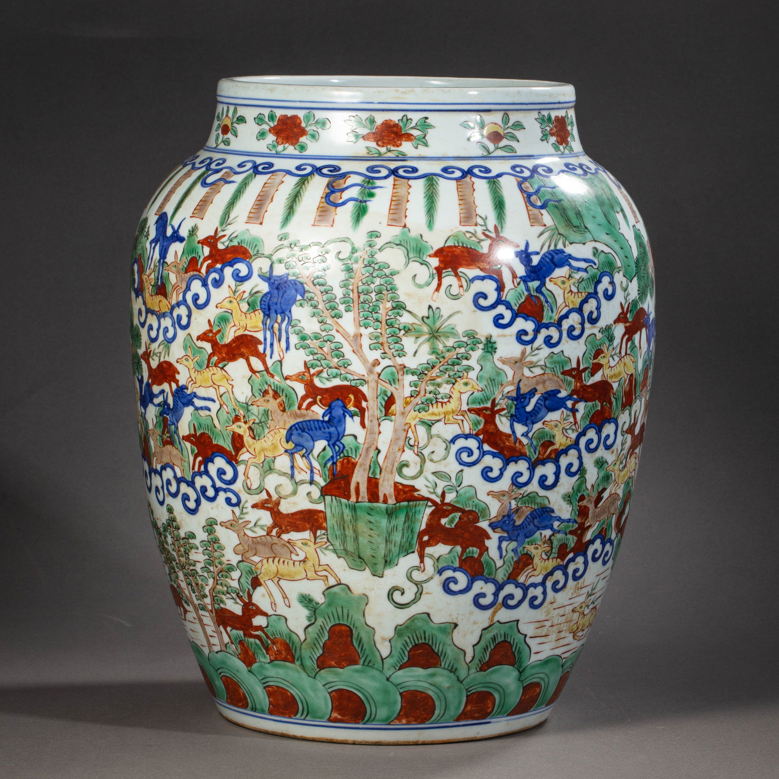 A RARE AND MAGNIFICENT 'DOUCAI' 'HUNDRED DEER' JARMARK AND PERIOD OF WANLI (1368-1644): Description The jar is stoutly potted with a robust globular body rising from a recessed base to a short, waisted neck and a rounded rim. The exterior is brilliantly decorated in the Doucai technique,