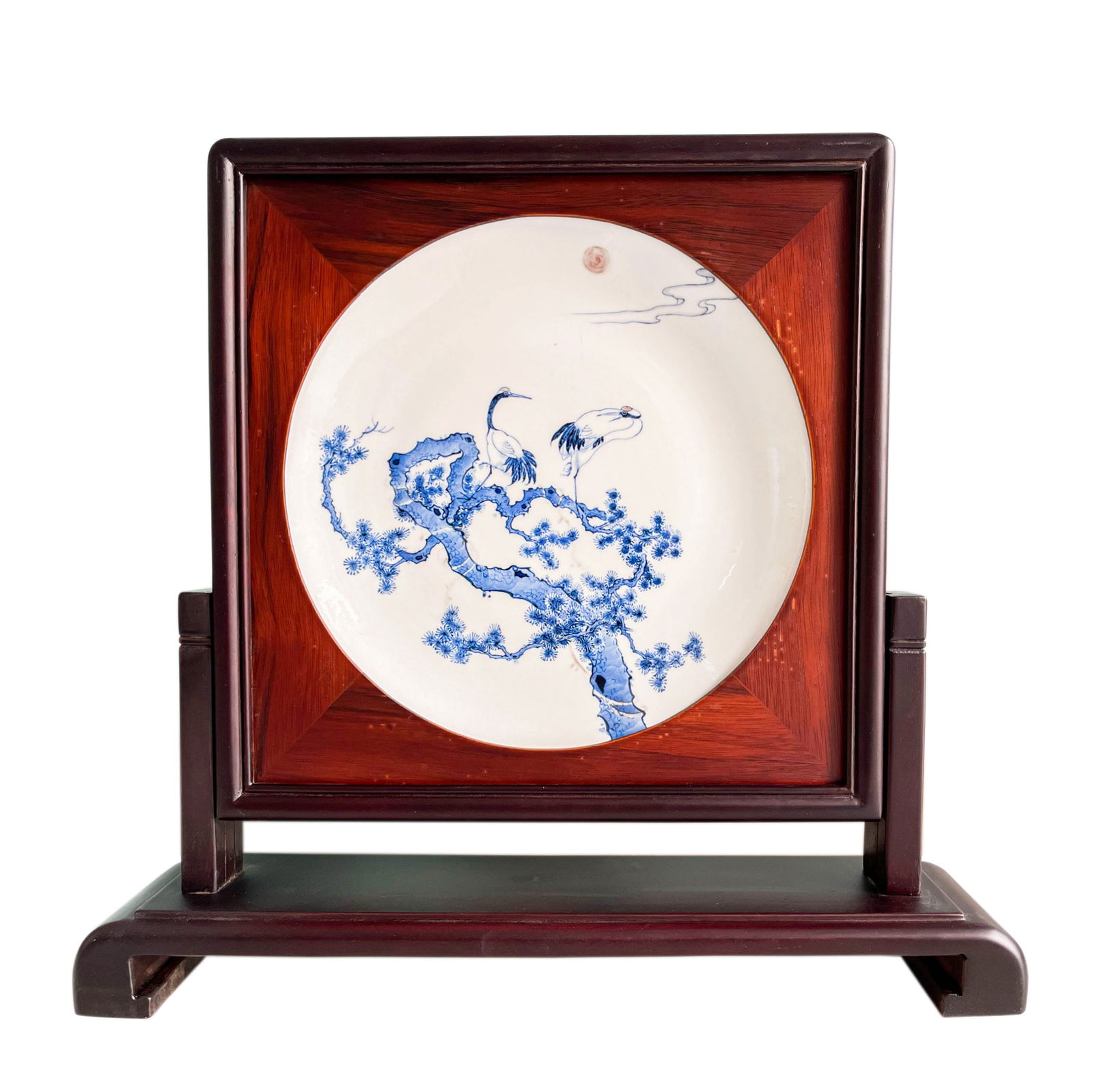 A BLUE AND WHITE 'CRANE AND PINE' PORCELAIN TABLE SCREENLATE QING DYNASTY OR REPUBLIC PERIOD, 19TH -: Description The lot features a circular blue and white porcelain plate masterfully inset into a rectangular wooden table screen. The porcelain center is vibrantly painted in underglaze cobalt blue wit