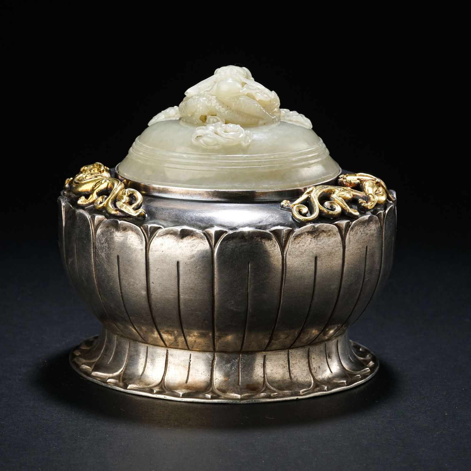 A RARE AND MAGNIFICENT IMPERIAL PART-GILT SILVER AND WHITE JADE-INLAID COVERED BOWLQIANLONG: DescriptionThe vessel is masterfully fashioned from heavy, high-purity silver, featuring a deep rounded body supported by a short foot. The exterior is exquisitely decorated with part-gilt floral scro