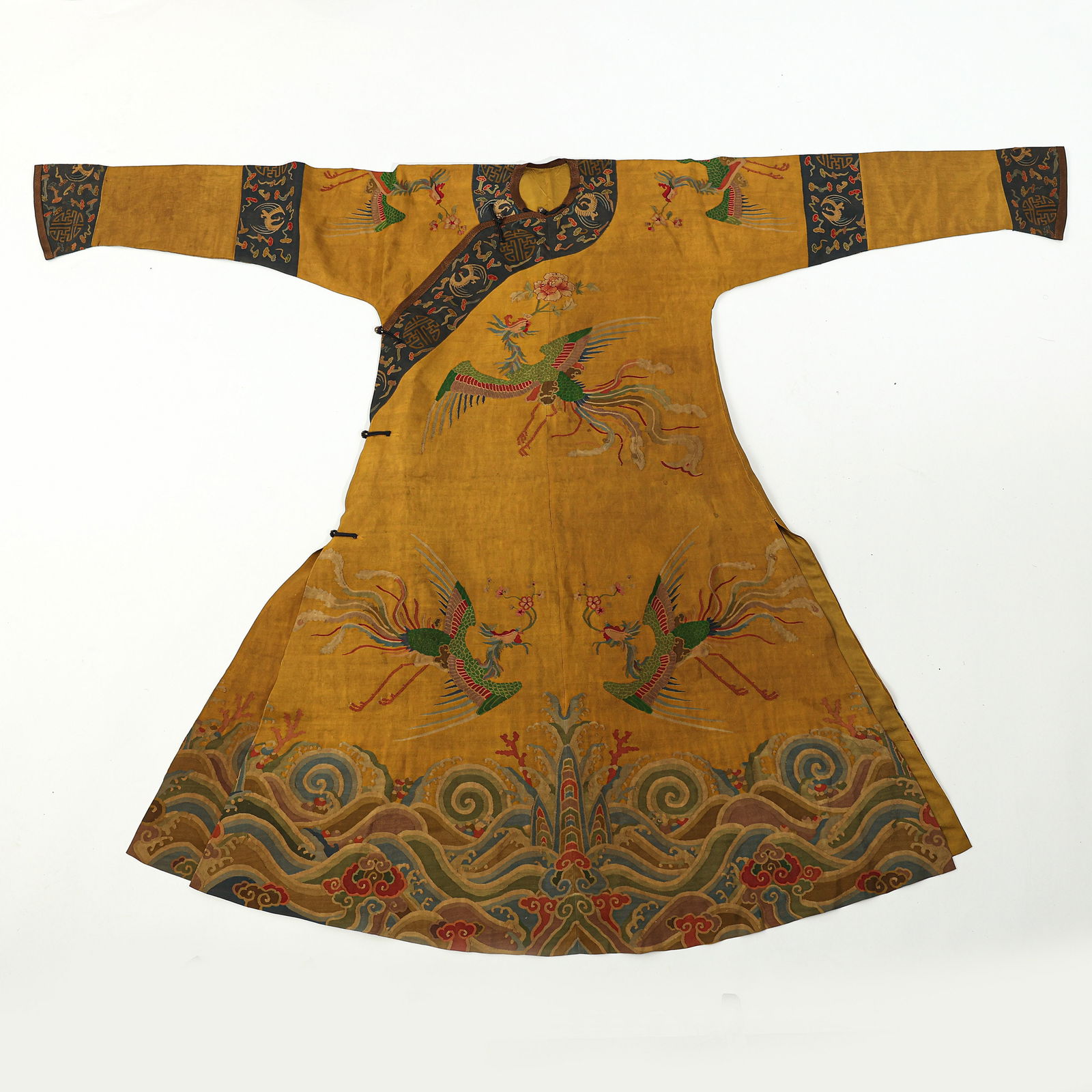 A MAGNIFICENT AND RARE IMPERIAL YELLOW-GROUND 'KESI' PHOENIX ROBE,JIFUQING DYNASTY, 19TH CENTURY: The robe is meticulously woven using the kesi (silk tapestry) technique, featuring a brilliant imperial yellow ground. It is opulently decorated with elegant phoenixes (fenghuang) in flight, their lon