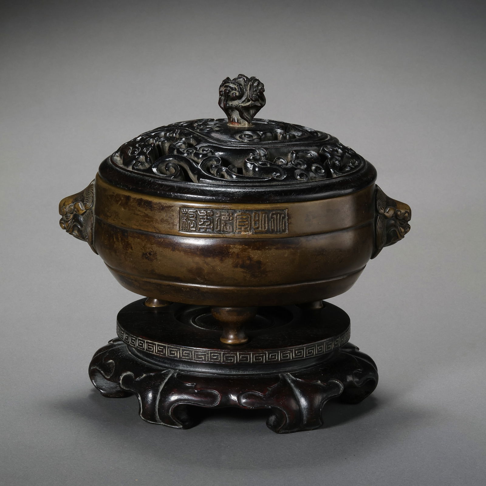 A RARE BRONZE 'LION-MASK' TRIPOD CENSER WITH IMPERIAL SIX-CHARACTER MARKMING DYNASTY (1368–1644): DescriptionThis elegantly cast bronze censer is of a compressed globular body, rising from three tapered beast-mask feet (shou-zu). The vessel is flanked by two powerfully rendered lion-mask handles (