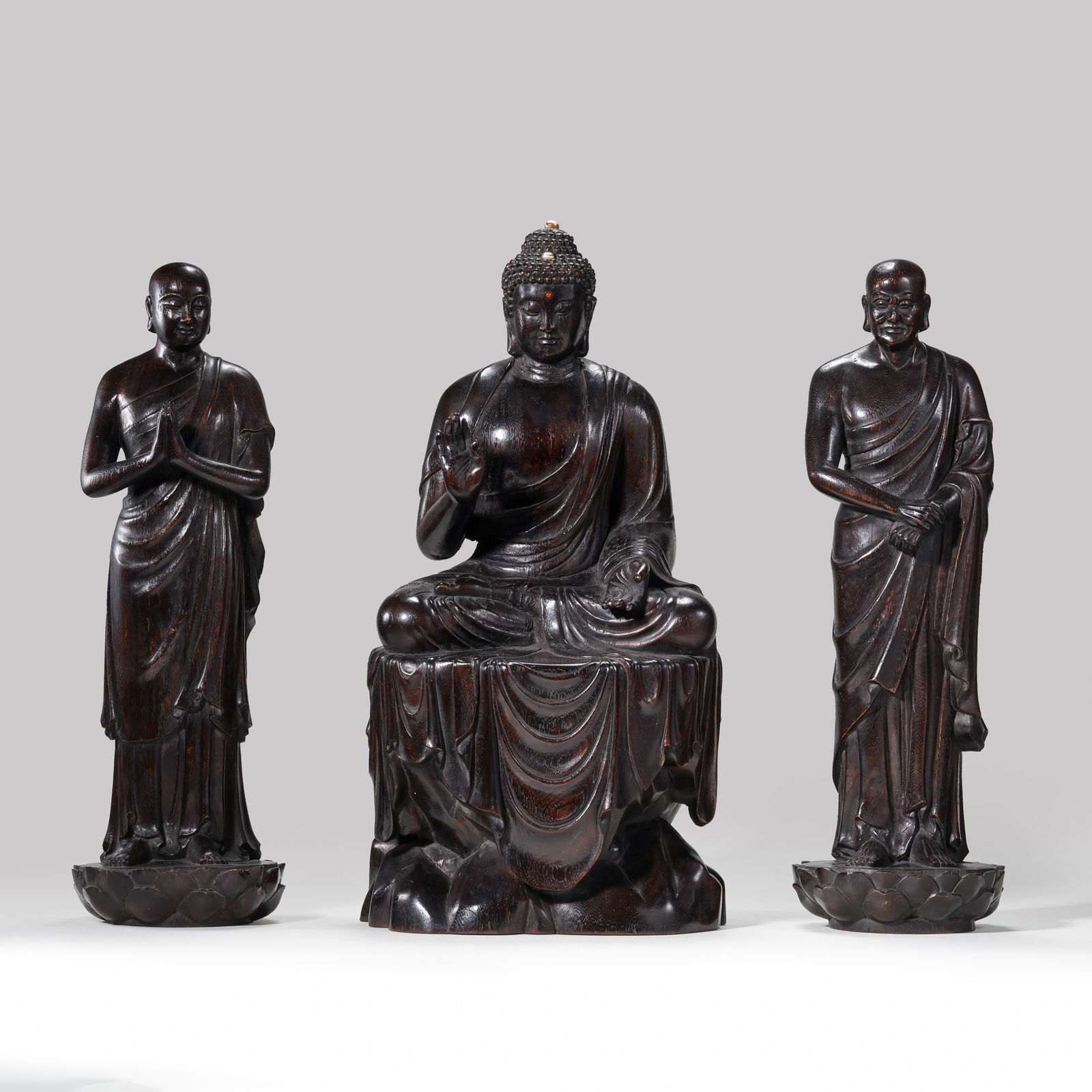 A RARE AND MAGNIFICENT GROUP OF THREE ZITAN WOOD FIGURESCOMPRISING SHAKYAMUNI BUDDHA AND TWO: Description This monumental and exceptionally rare ensemble is masterfully carved from solid, premium-grade Zitan wood (Pterocarpus santalinus). The set comprises a central seated figure of Shakyamuni