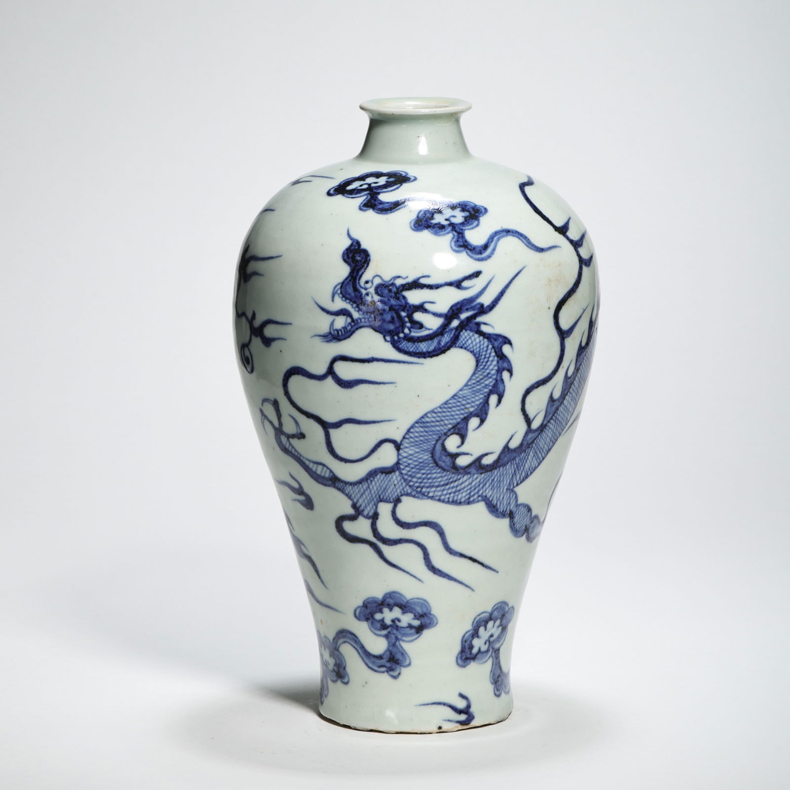 A RARE BLUE AND WHITE 'DRAGON' MEIPINGYUAN DYNASTY (1279-1368): The vase is sturdily potted with a characteristic meiping form, featuring a short waisted neck with a flared rim, broad swelling shoulders, and a body tapering down to a slightly flared foot. The exte