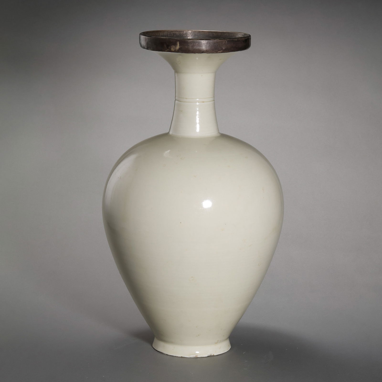 A MAGNIFICENT AND RARE DING WHITE-GLAZED 'DISH-MOUTH' VASESONG DYNASTY (960–1279 AD): Description This monumental vase is an exceptional paradigm of the understated elegance that defined the Song Dynasty aesthetic. The vessel is characterized by its dramatic "Dish-Mouth" (pan-kou), a s