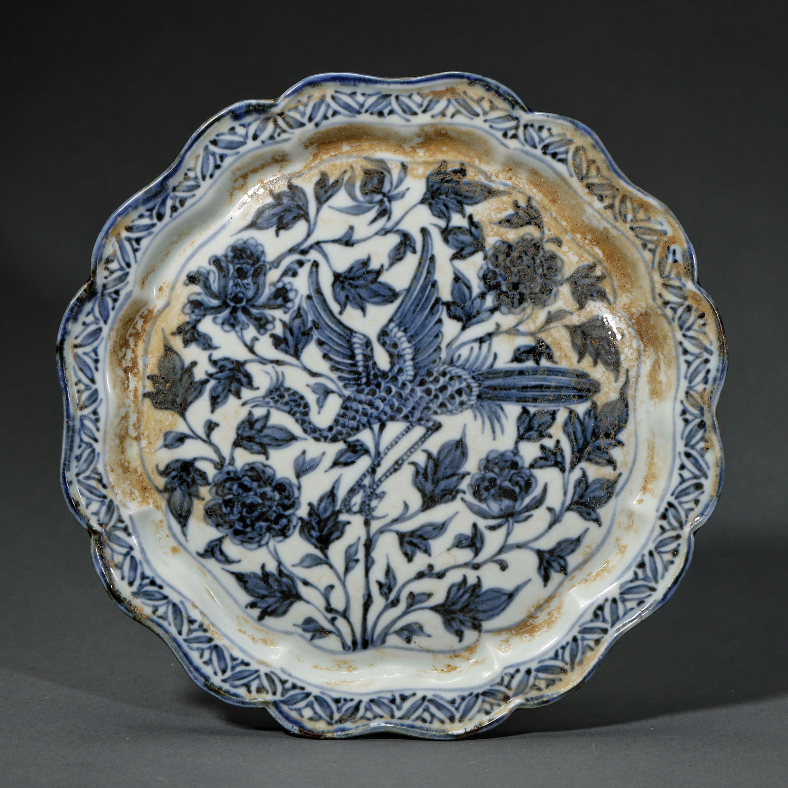 A RARE BLUE AND WHITE 'PEACOCK AND PEONY' DISHYUAN DYNASTY OR MING INTERREGNUM PERIOD (14TH–15TH: Description This elegantly potted dish is a significant example of early Chinese blue and white porcelain development. It features a shallow rounded body, gently flaring to a slightly everted rim, res