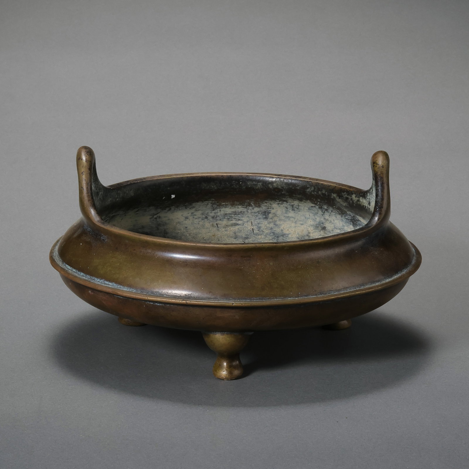 A RARE AND MAGNIFICENT BRONZE TRIPOD CENSER,CHONGTIAN-ERMING DYNASTY (1368–1644): Description This exquisitely proportioned bronze censer is of a classic compressed globular form, supported by three tapered nipple-shaped feet (ru-zu). Rising from the flared rim are a pair of elegan