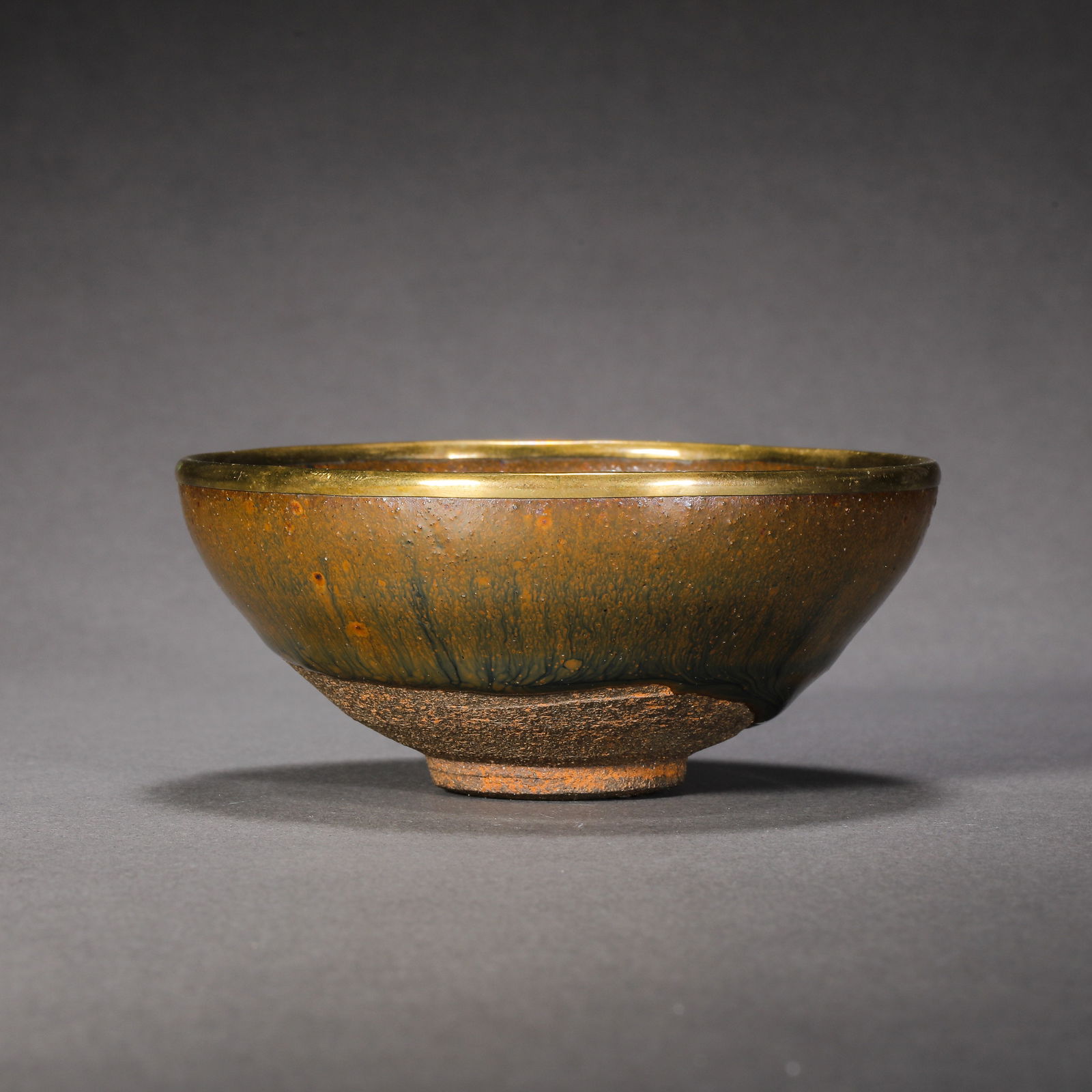 RARE 'JIAN' HARE'S FUR-GLAZED TEA BOWL WITH METAL-BOUND RIMSOUTHERN SONG DYNASTY (1127–1279): The tea bowl is masterfully potted with deep, subtly waisted sides rising from a short, tapered foot to a slightly flared rim, which is elegantly bound with a metal band. The interior and exterior are